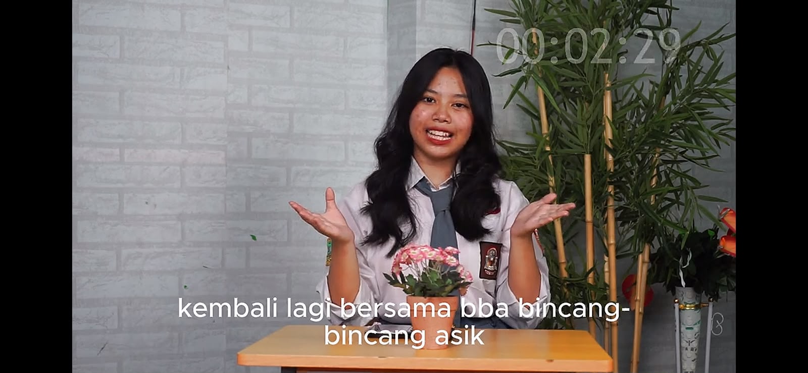 Host Podcast — Mazaya sedang bincang-bicara di depan kamera dengan seragam sekolah